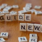 Close-up of Scrabble tiles spelling 'Guide' and 'News' on a wooden surface. — Join the Elite Unique Casino Experience