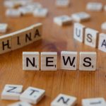 Wooden Scrabble tiles spelling 'NEWS' with 'CHINA' and 'USA' on a wooden surface. — Peut-on vraiment faire confiance aux lice