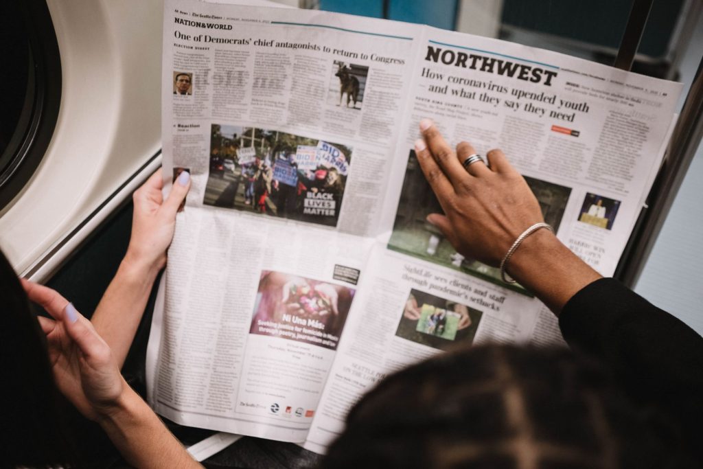 People reading a newspaper on a subway train, highlighting current events and diverse perspectives. — Welches Spielerlebnis e